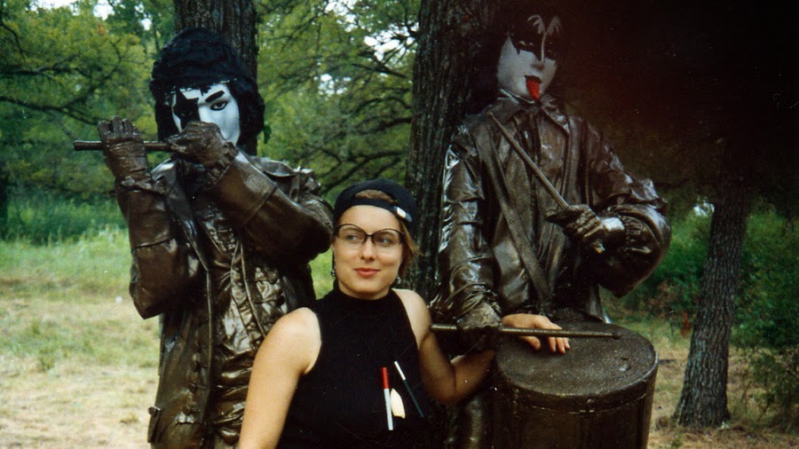 a woman posing with two statues