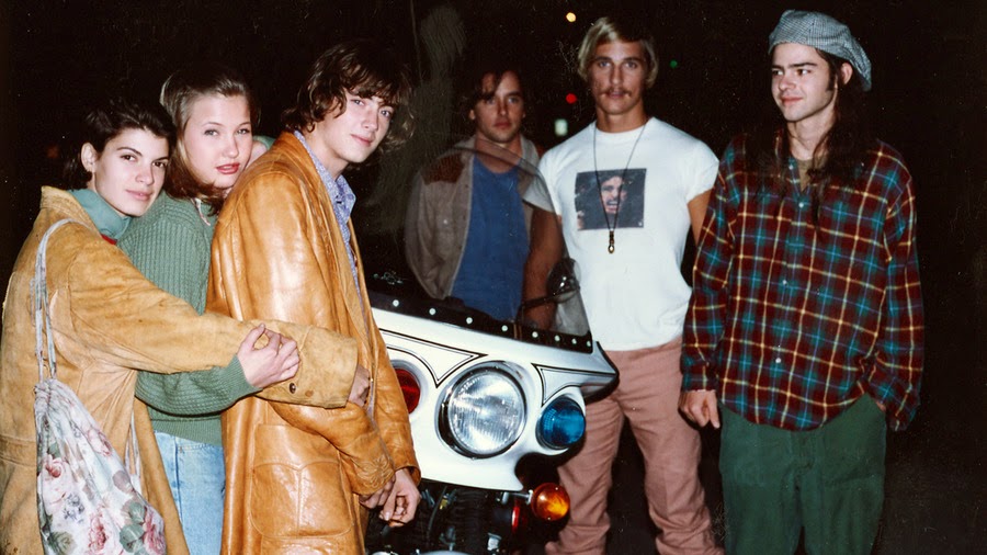 a group of people standing next to a motorcycle