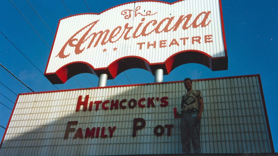 a man standing in front of a sign