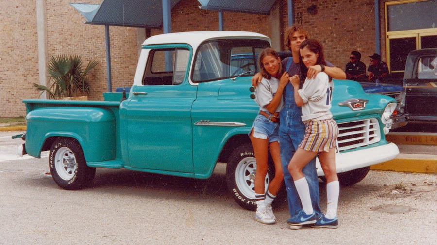 a group of people posing for a picture in front of a truck