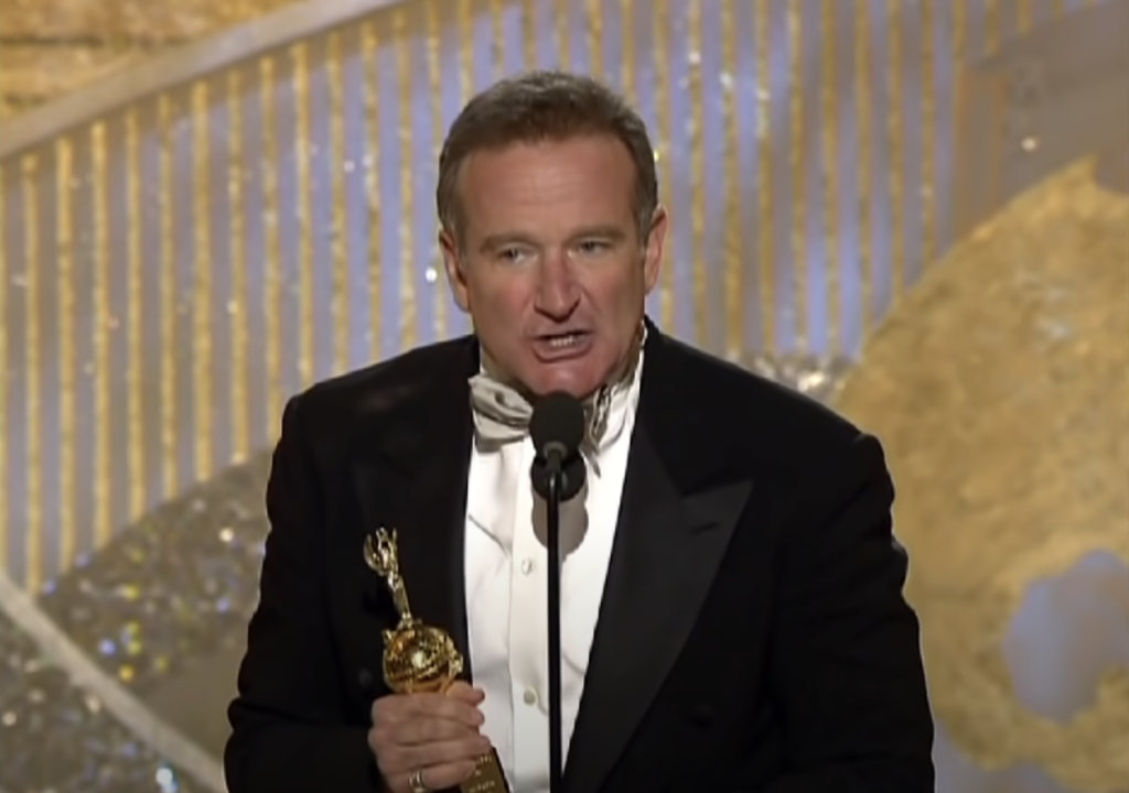 Robin Williams in a suit accepting an award