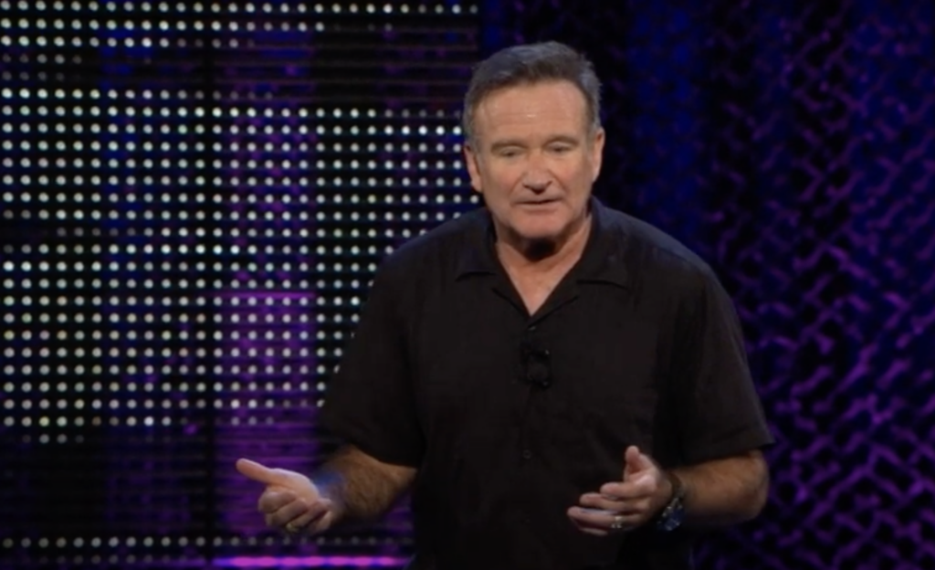 Robin Williams on stage telling a joke 