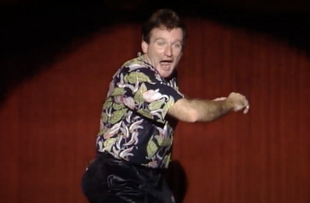 Robin Williams in a hawaiian shirt on stage