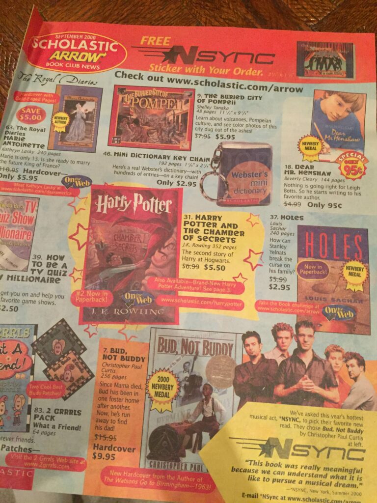 A vintage 1999 Scholastic book club flyer features popular books like Harry Potter and the Prisoner of Azkaban, Holes, Bud, Not Buddy, and Websters Mini Dictionary. An NSYNC sticker offer is also highlighted.