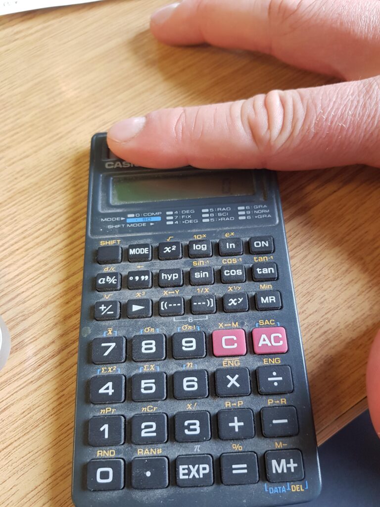 Someone covering up the solar panel on a calculator 