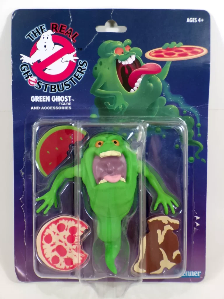 Packaging of The Real Ghostbusters Green Ghost action figure. This must-have piece for Ghostbusters Collectibles enthusiasts is green with a wide mouth and orange eyes, surrounded by detachable food items like pizza, watermelon, and bread. The card boasts colorful artwork of the ghost eating.