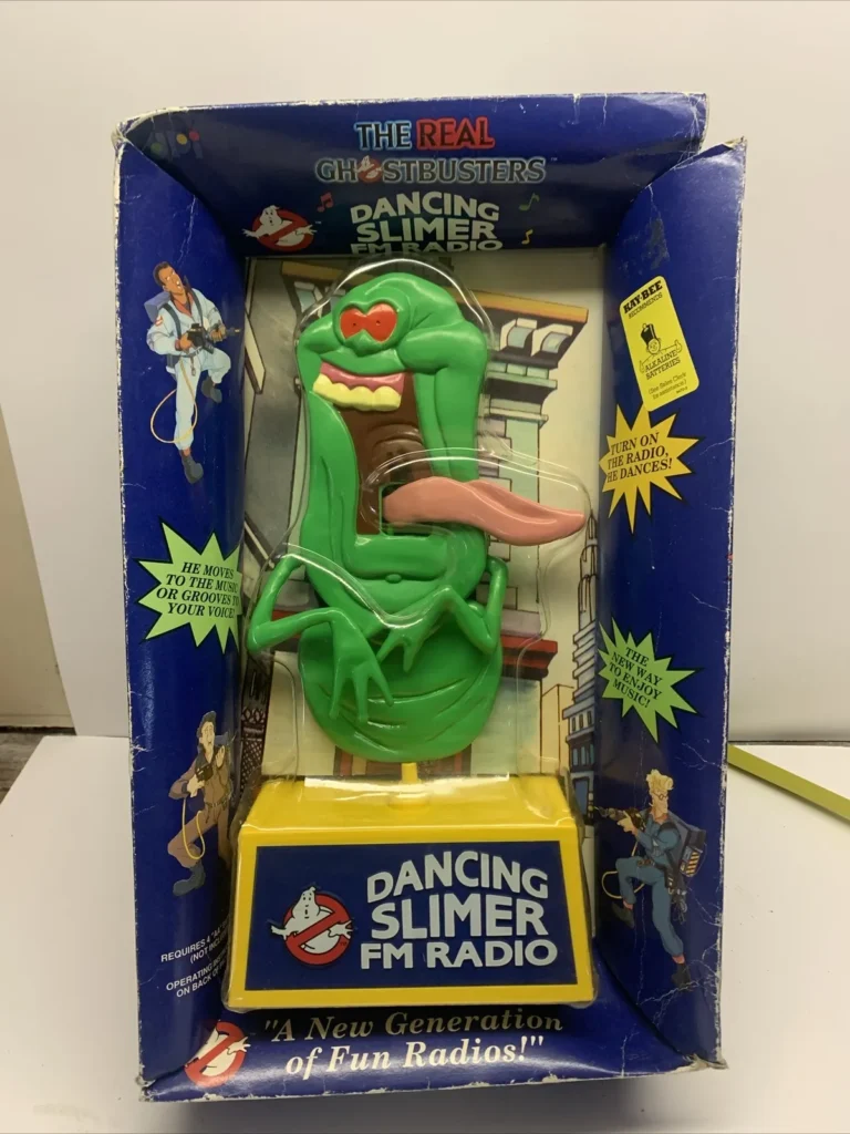 A boxed Dancing Slimer FM Radio from The Real Ghostbusters series is a must-have for Ghostbusters Collectibles enthusiasts. The box showcases Slimer in green with a playful expression, promoting a new generation of fun radios, decorated with various Ghostbusters-themed graphics.