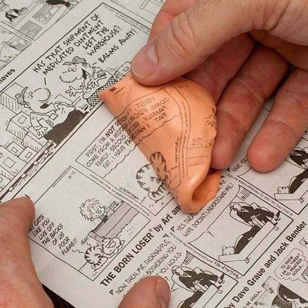 Silly putty pulling print off of a comic strip in a newspaper