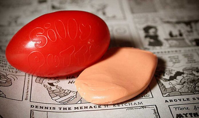 Silly Putty and it's egg container sitting on a comic strip in a newspaper