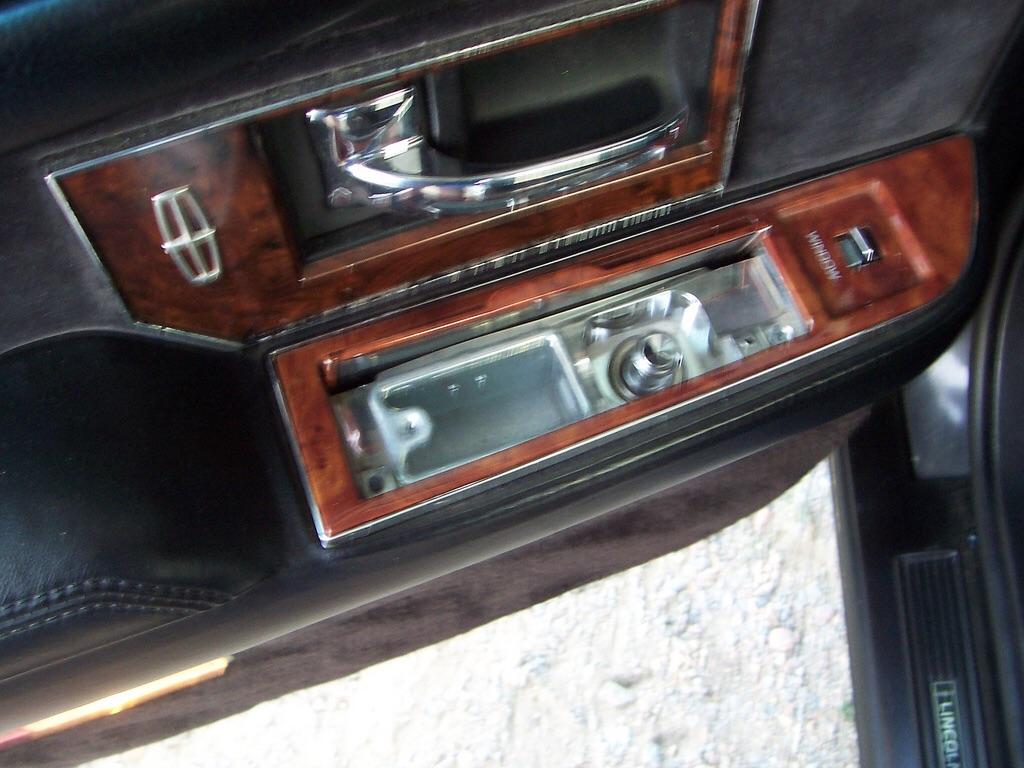 Photo of the inside of a car door that has an ash tray and a cigarette lighter