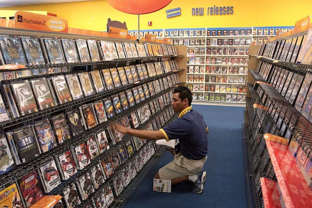 Super popular 90s things - Man restocking a shelf at a 90s Blockbuster video