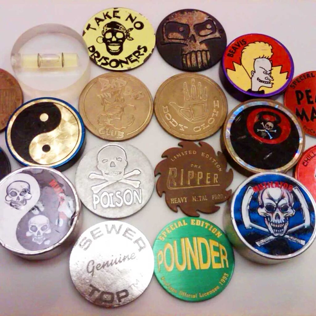 Collection of Pog Slammers including a brass Body Glove slammer, a brass Bad Boy Club slammer, and a Beavis slammer