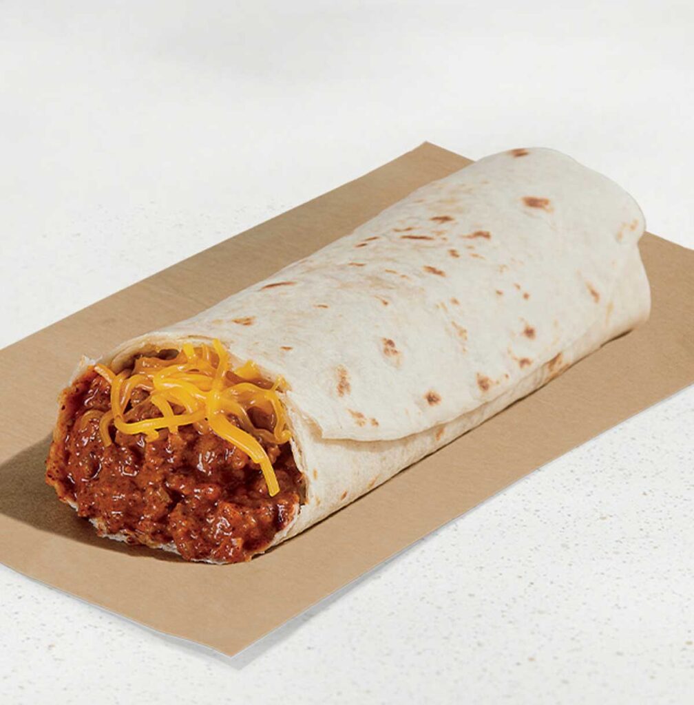 A soft tortilla envelops a filling of seasoned beef or beans mixed with chili sauce, topped with shredded cheddar cheese—reminiscent of those beloved discontinued Taco Bell menu items—served on a piece of brown paper on a white surface.