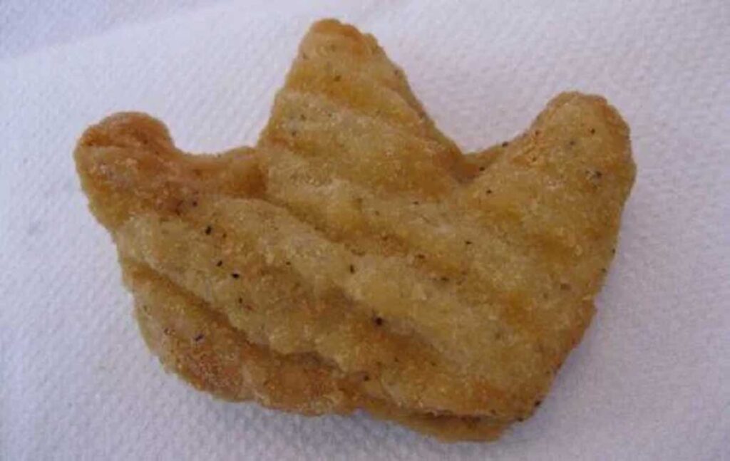 Discontinued Burger King item - Crown Shaped Nuggets. A chicken nugget shaped like a crown, reminiscent of discontinued fast food items, rests on a white paper towel.