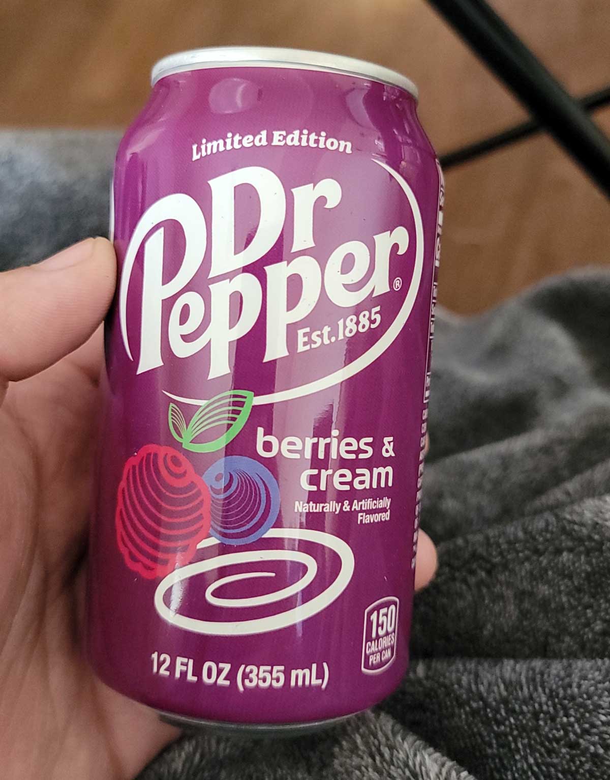 A hand holding a can of Dr. Pepper Berries and Cream
