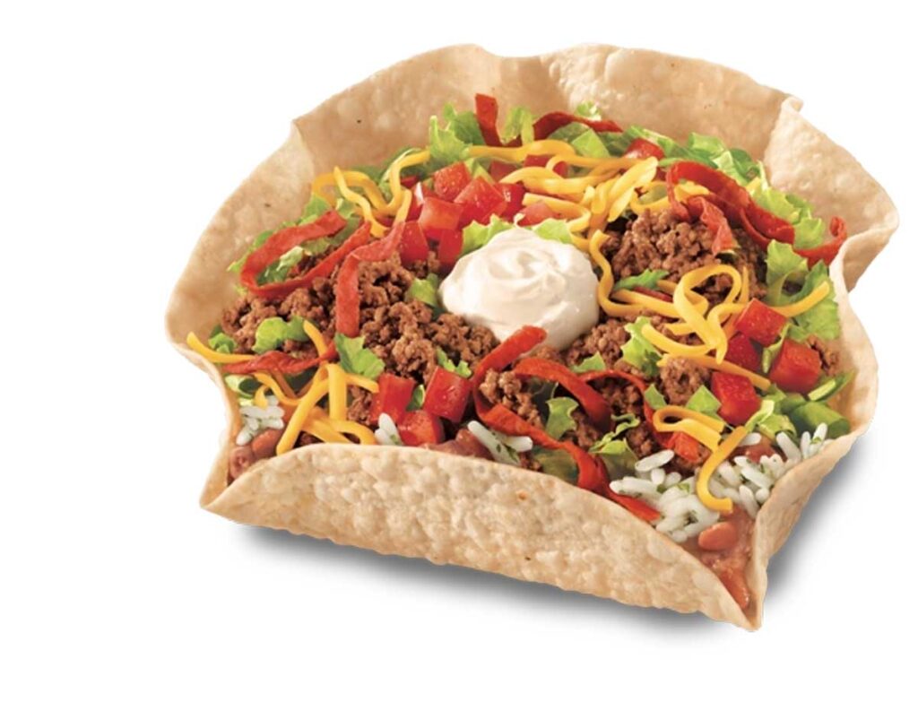 A crispy tortilla bowl reminiscent of discontinued Taco Bell menu items, filled with seasoned ground beef, shredded lettuce, diced tomatoes, cheddar cheese, rice, beans, and a dollop of sour cream.