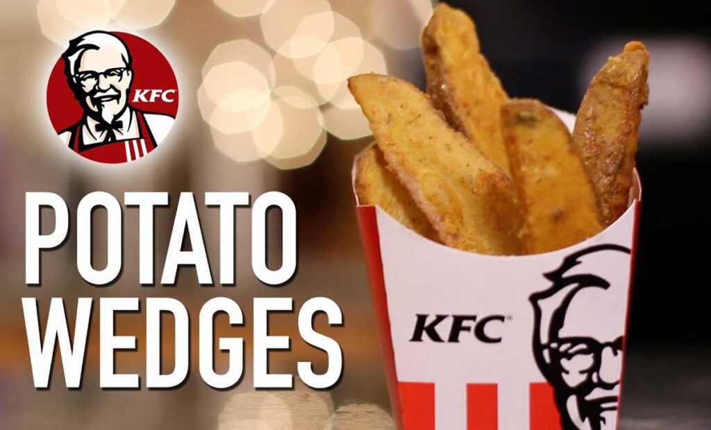 A red and white KFC container brims with golden-brown potato wedges, a delightful nod to discontinued fast food items. The iconic Colonel beams from the logo, while "Potato Wedges" stands out on the left against a blurred backdrop.