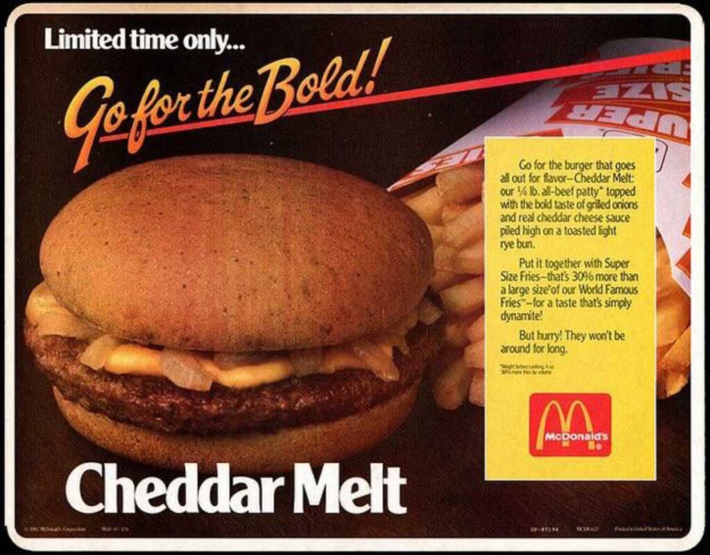 Advertisement poster for McDonald's Cheddar Melt. Featuring a savory burger with melted cheddar cheese and grilled onions on a rye bun, paired with crispy fries. Text highlights this bold and flavorful creation, reminiscent of beloved discontinued fast food items, available for a limited time only.