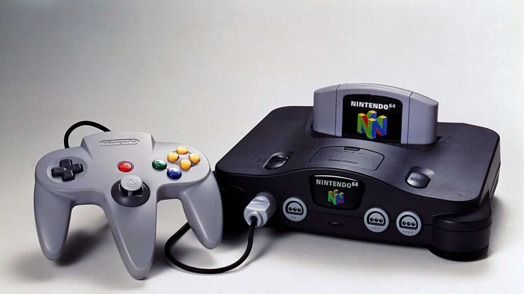 A Nintendo 64 console, one of the best-selling video game consoles, comes with a gray controller. The sleek black console features a game cartridge in place. The vibrant controller’s colorful buttons and connecting cord are plugged into the first port of this iconic gaming system.