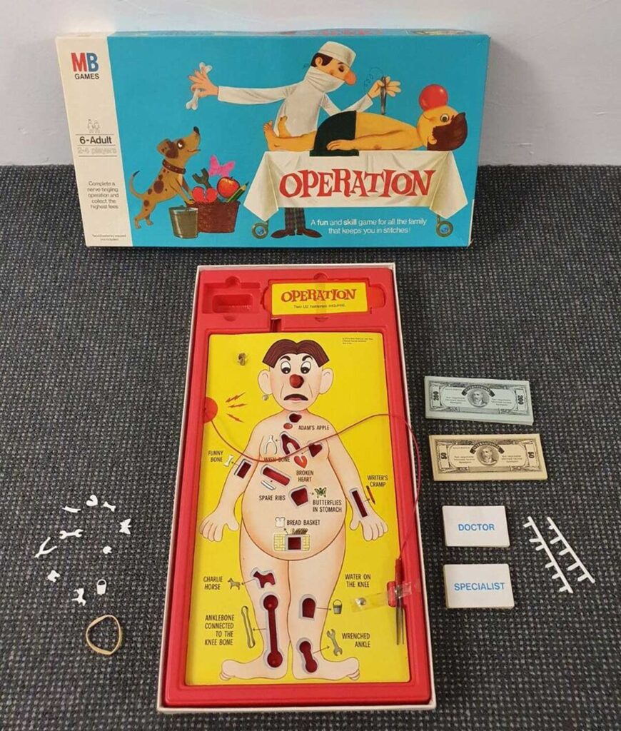 Box and board of the Operation game, featuring cartoon art of a surgeon. The board displays a patient with removable body parts, metal tweezers, and game money. Included are cards labeled Doctor and Specialist.