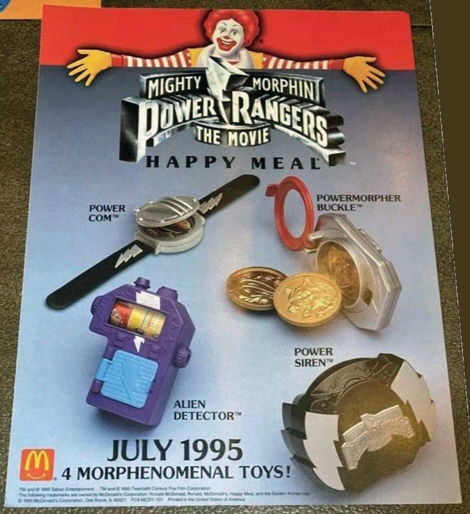 Promotional poster for McDonalds 1995 Mighty Morphin Power Rangers: The Movie Happy Meal, featuring four toys: Powercom watch, Powermorpher buckle, Alien detector, and Power siren. Ronald McDonald is at the top with a July 1995 release date.