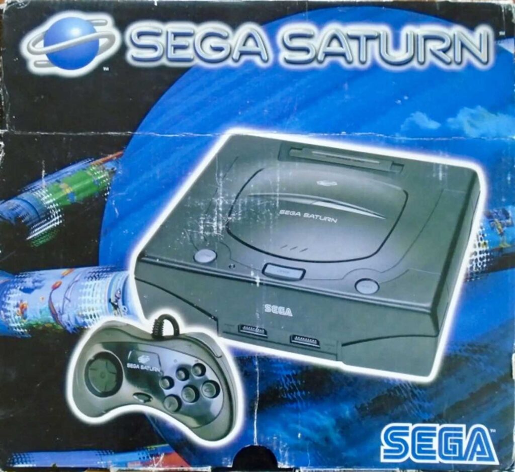 The image showcases the cover of a Sega Saturn console box, highlighting one of the best-selling video game consoles. It features the Sega Saturn console and controller against a space-themed backdrop, with the iconic Sega Saturn and Sega logos prominently displayed.