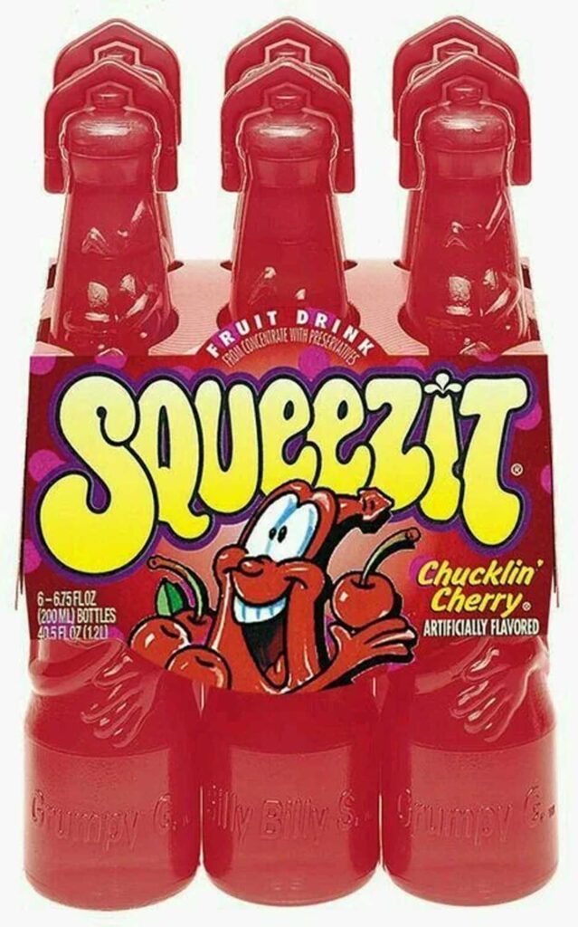 A pack of red Squeezit fruit drink bottles with Chucklin Cherry flavor labels, reminiscent of discontinued snacks from the 90s. The packaging features a cheerful cartoon cherry character, and each bottle has a twist-off top shaped like a face.