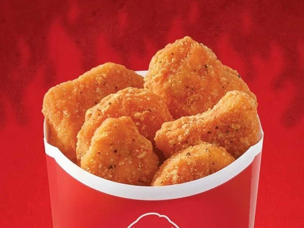 A red container filled with crispy, breaded chicken nuggets sits invitingly against a red background, reminiscent of beloved yet discontinued fast food items.