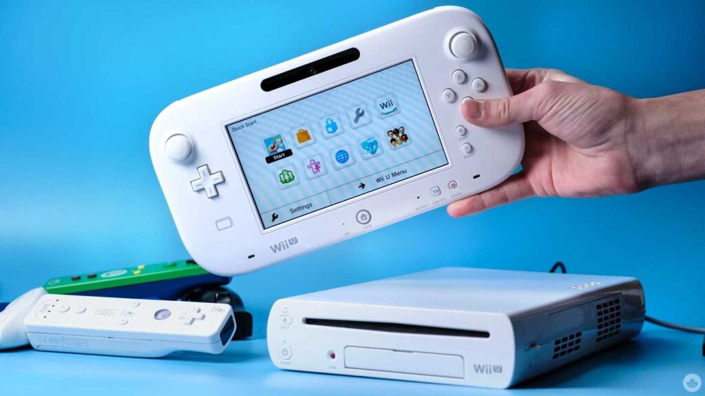 A person holds a white Wii U GamePad against a blue background. Below, the console and accessories like the Wii Remote and green Nunchuk sit nearby. The screen features various app icons, highlighting one of Nintendo's ventures into best-selling video game consoles.