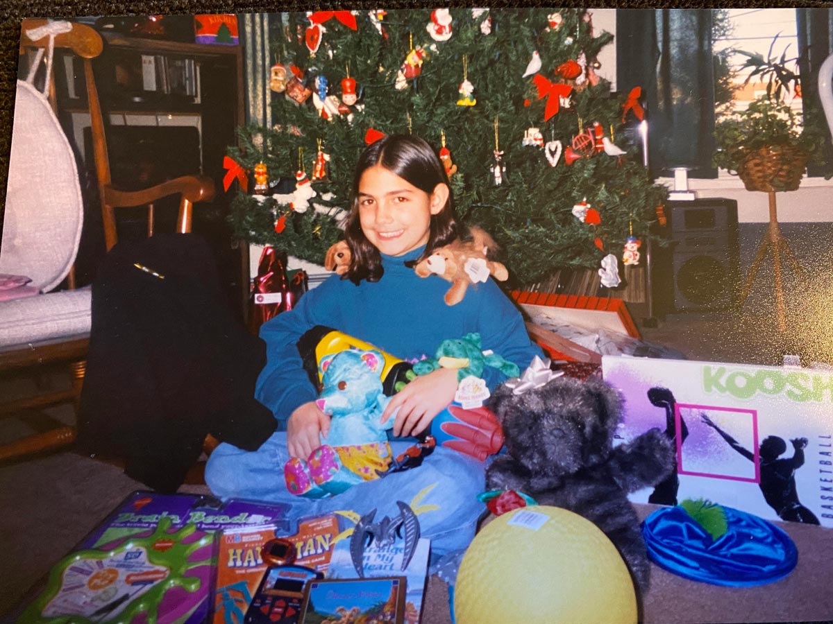 Kid showing over her Christmas Morning presents haul in front of the tree. 