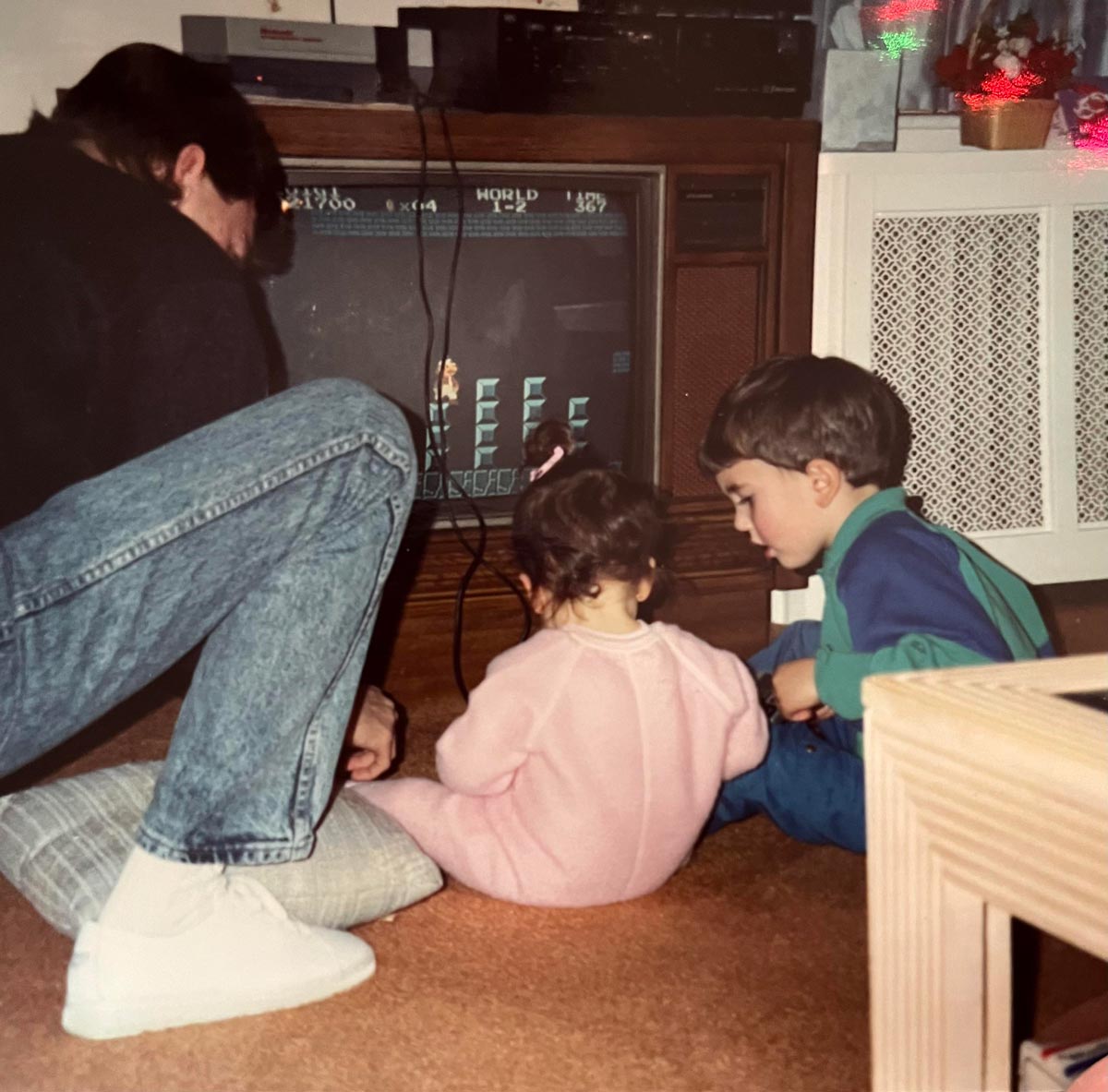 A dad and two kids playing Mario Brothers on Christmas morning in 1992.