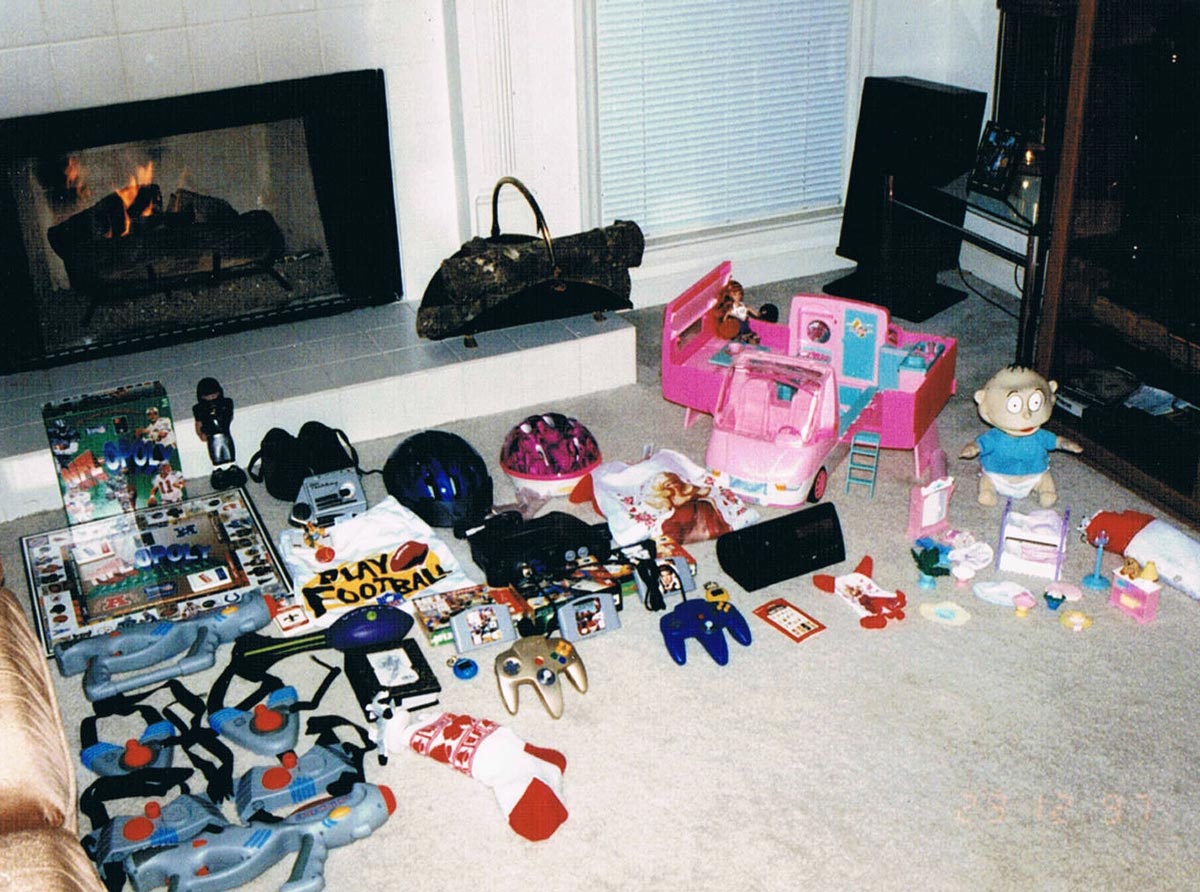 Christmas morning in the 90s and all the toys are spread out like a Tommy Pickles doll, laser tag set, Talkboy, and a N64.