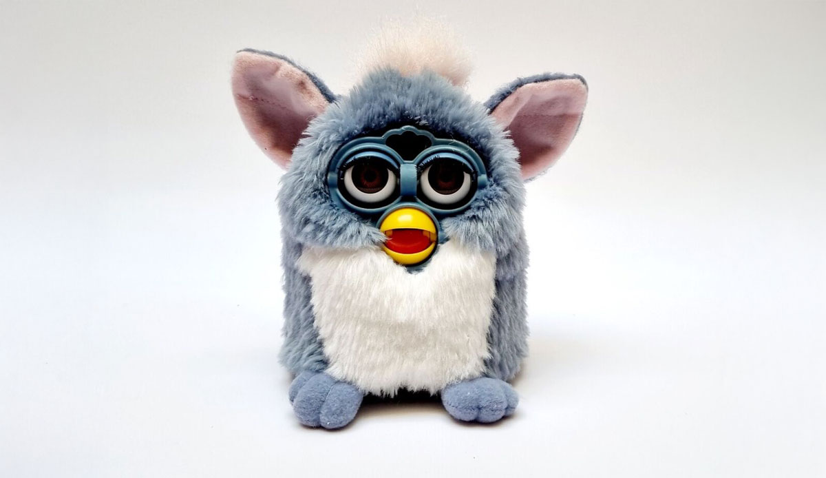 A grey and white furry toy with large eyes and a beak-like mouth sitting against a plain white background. The toy has big pointed ears and a tuft of fur on top of its head.