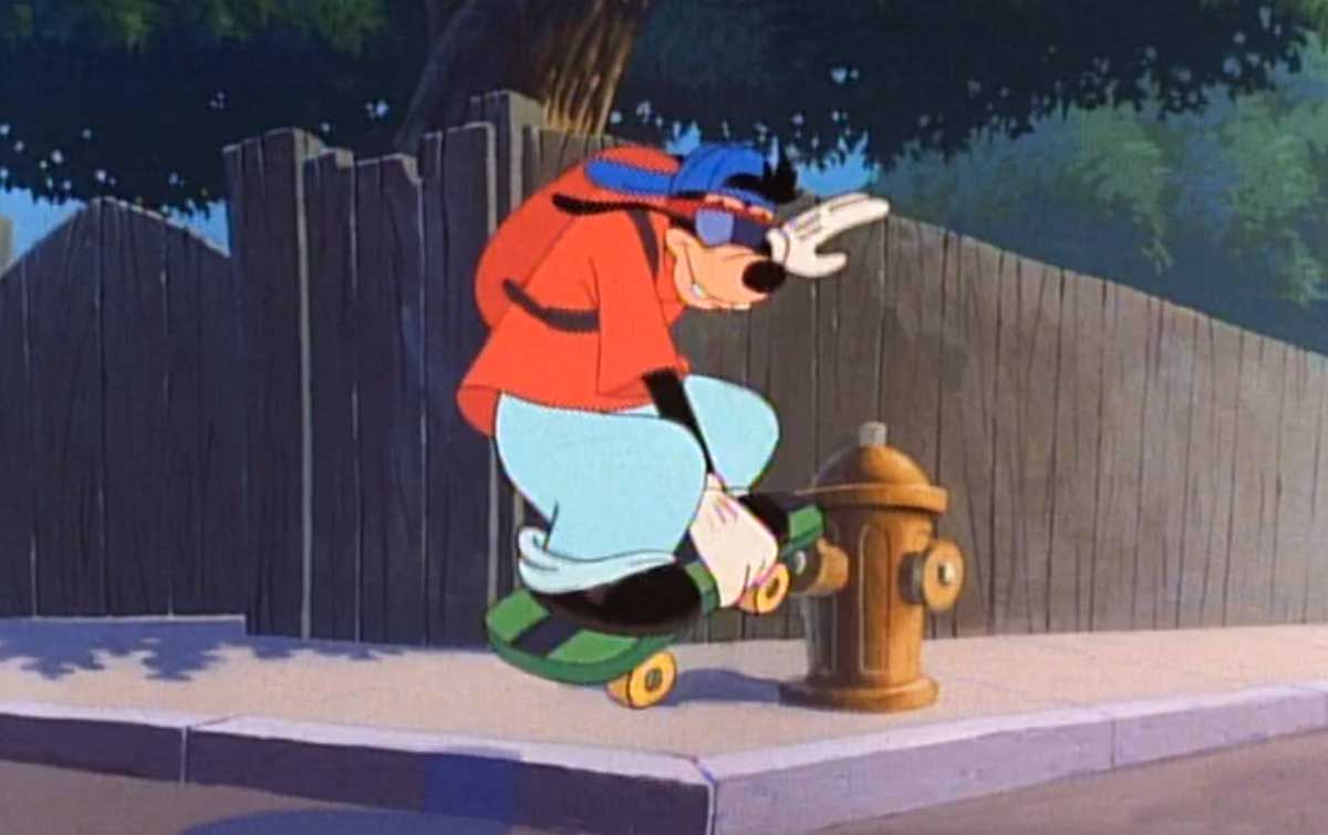 A cartoon character wearing a cap, red shirt, and blue pants rides a skateboard down a sidewalk and jumps over a yellow fire hydrant. A wooden fence and trees are in the background.