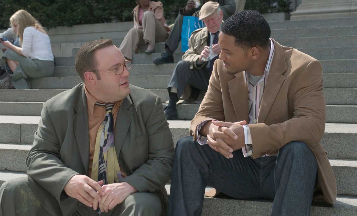 Kevin James and Will Smith sitting on some stairs in a still from the movie Hitch.