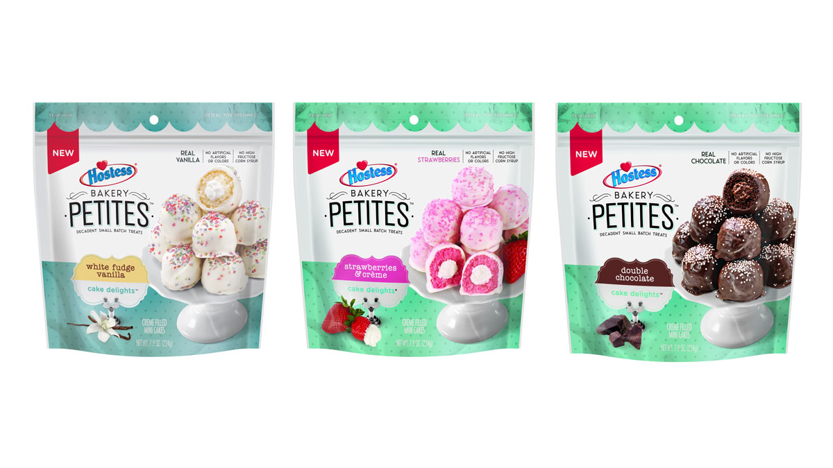 Three packages of Hostess Bakery Petites are displayed: White Fudge Vanilla, Strawberries and Creme, and Double Chocolate. Each package shows colorful desserts on a small white stand against a green background.