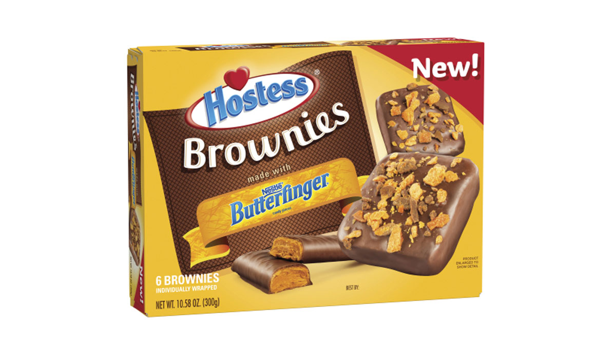 Box of Hostess Brownies featuring Butterfinger flavor. The packaging shows six brownies with chocolate coatings and crunchy toppings. The word New! is highlighted in the top right corner. Net weight is 10.89 oz (308 g).