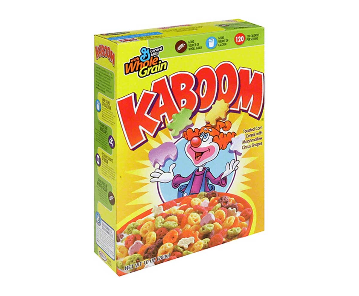 Box of Kaboom cereal that features a clown juggling three different shaped marshmallows in front of a bowl of cereal. 