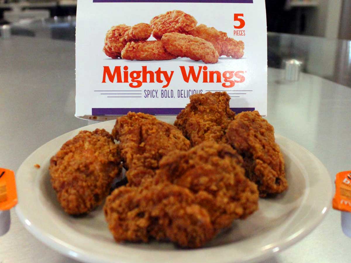 Plate of McDonald's Mighty Wings with the original packaging behind it.