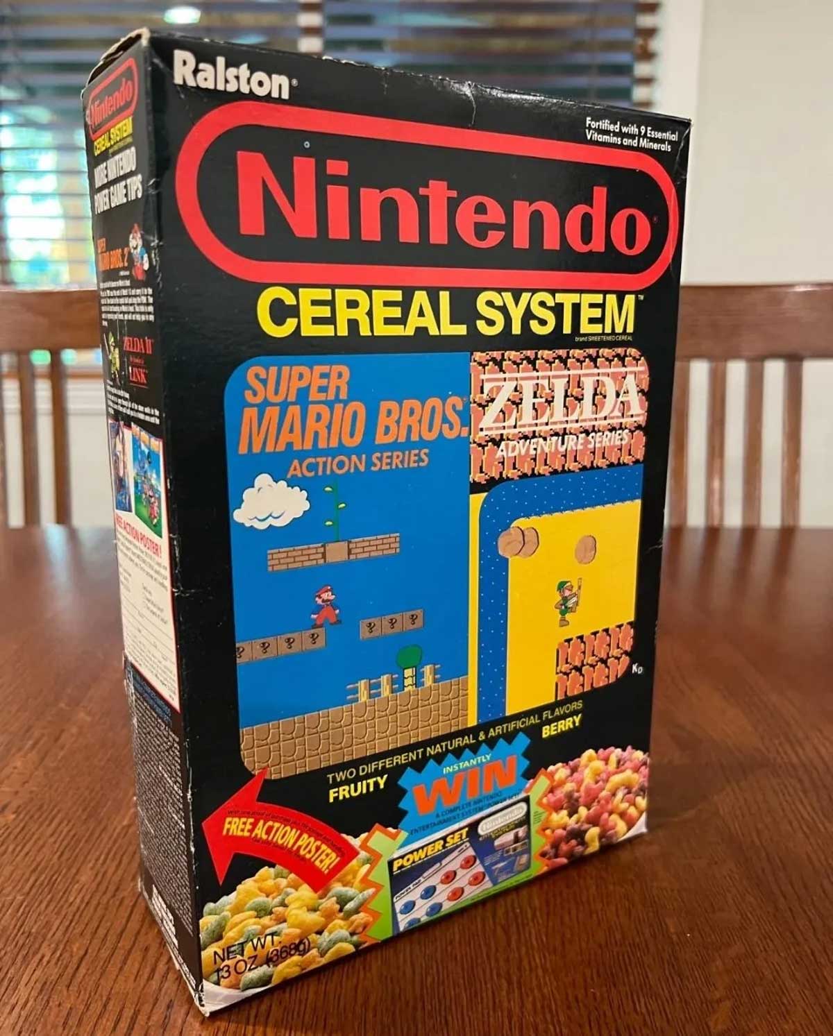 A vintage box of Nintendo Cereal System sits on a wooden table. The box showcases Super Mario Bros. and The Legend of Zelda themes, with colorful cereal pieces pictured at the bottom.