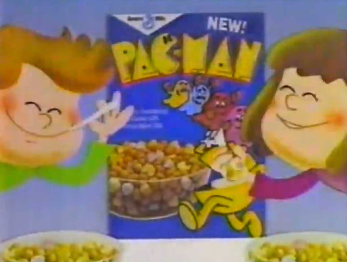 Illustration of two cartoon children savoring bowls of  cereal in front of a box labeled New! Pac-Man. The cereal box showcases characters from the iconic game, featuring a yellow Pac-Man figure and colorful ghosts.