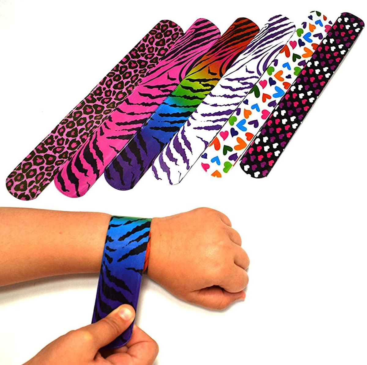 A person is snapping a bracelet onto their wrist. Several colorful slap bracelets with patterns like animal prints, rainbow stripes, and hearts are displayed, showcasing their variety.