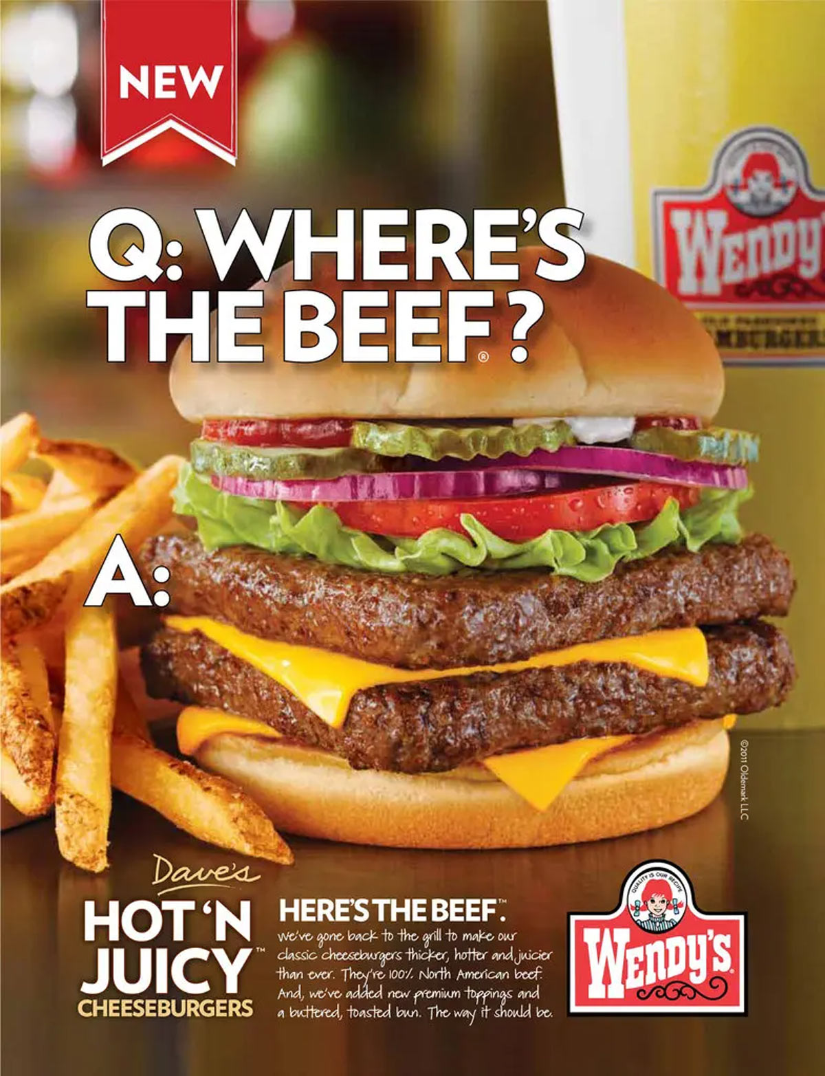Advertisement featuring a Wendys cheeseburger with lettuce, tomato, and pickles, accompanied by fries. Text reads Q: Wheres the beef? and promotes Daves Hot n Juicy Cheeseburgers. Wendys logo included.