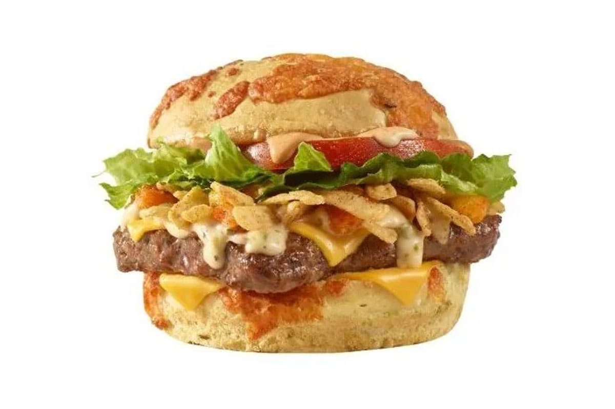 The discontinued Wendy's Loaded Nacho Cheeseburger. A cheeseburger with a toasted bun topped with melted cheese, crispy fried onions, leafy lettuce, tomato slices, and a beef patty, with a creamy sauce drizzled over the layers.