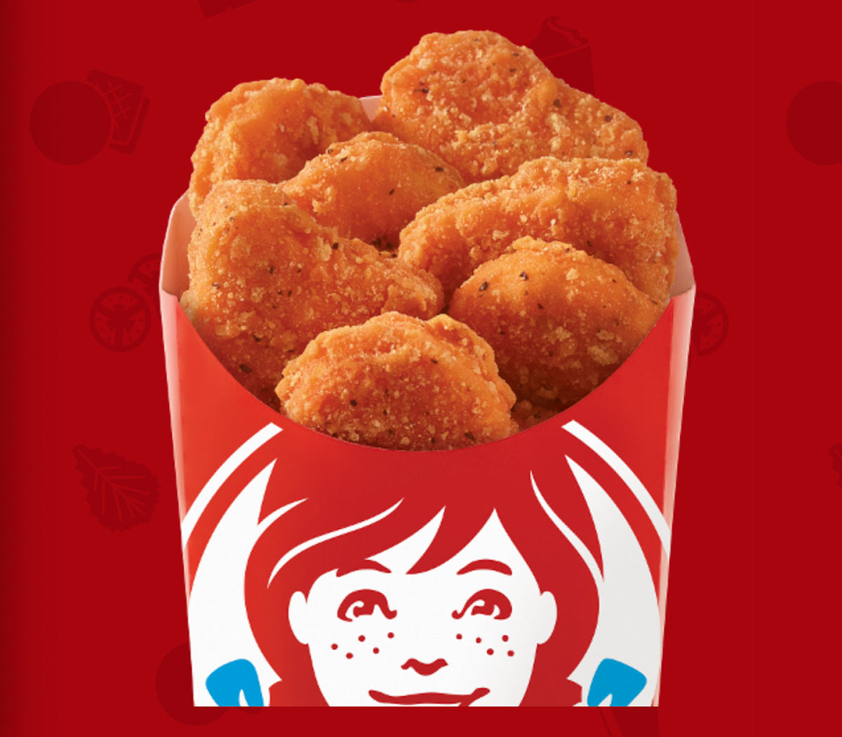 A box of crispy chicken nuggets in a red container featuring a cartoon drawing of a girl with red hair and freckles. The background is a solid red color with faint icons.