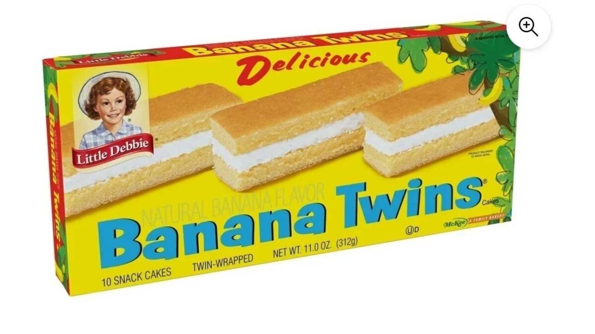 Image of a box of Little Debbie Banana Twins. The packaging is bright yellow and green with an illustration of banana trees. It contains 10 twin-wrapped, natural banana-flavored snack cakes, weighing 11 ounces in total.