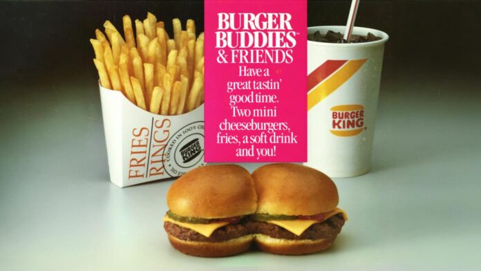 A Burger King meal with two mini cheeseburgers, a container of fries, and a soft drink. A sign above reads, “Burger Buddies & Friends: Two mini cheeseburgers, fries, a soft drink and you!”.