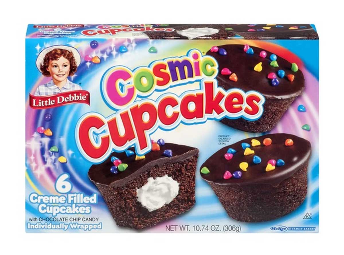A box of Little Debbie Cosmic Cupcakes is shown, featuring a colorful design. The package contains six creme-filled chocolate cupcakes topped with colorful candy sprinkles. The net weight is 10.74 oz (306g).
