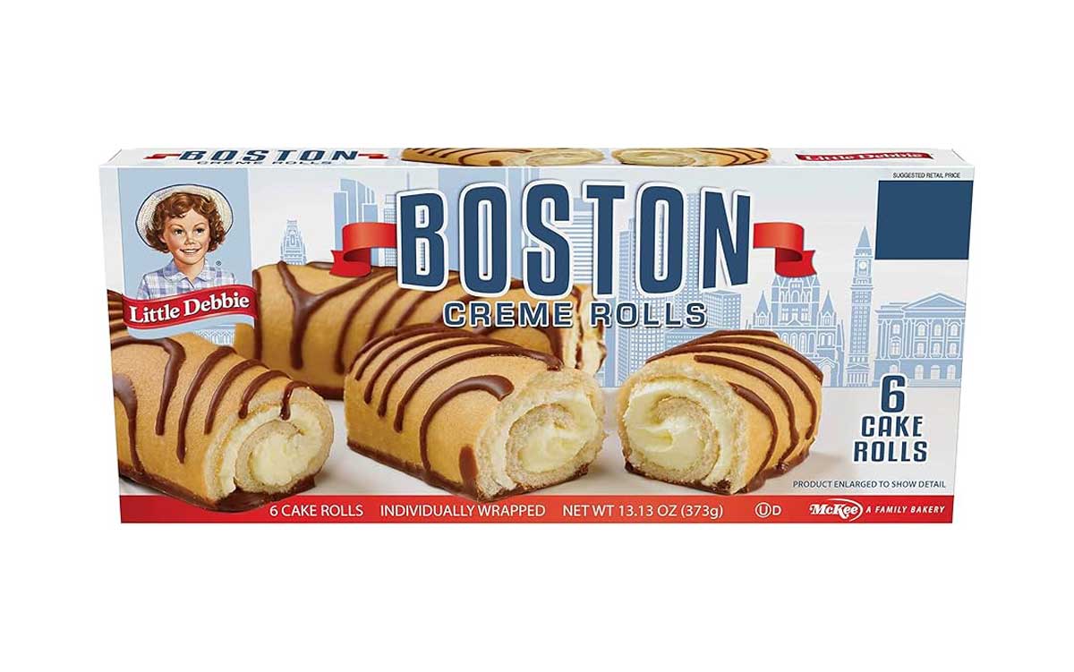 Box of Little Debbie Boston Creme Rolls featuring six individually wrapped cake rolls filled with cream and drizzled with chocolate; packaging shows city skyline graphics and the Little Debbie logo.
