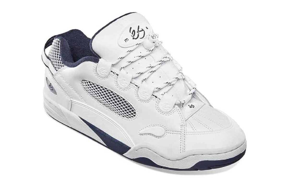 A white skate shoe with black accents, mesh side panels, thick laces, and a chunky sole. The tongue and heel feature embroidered logos. The shoe has a low-top design and visible stitching.